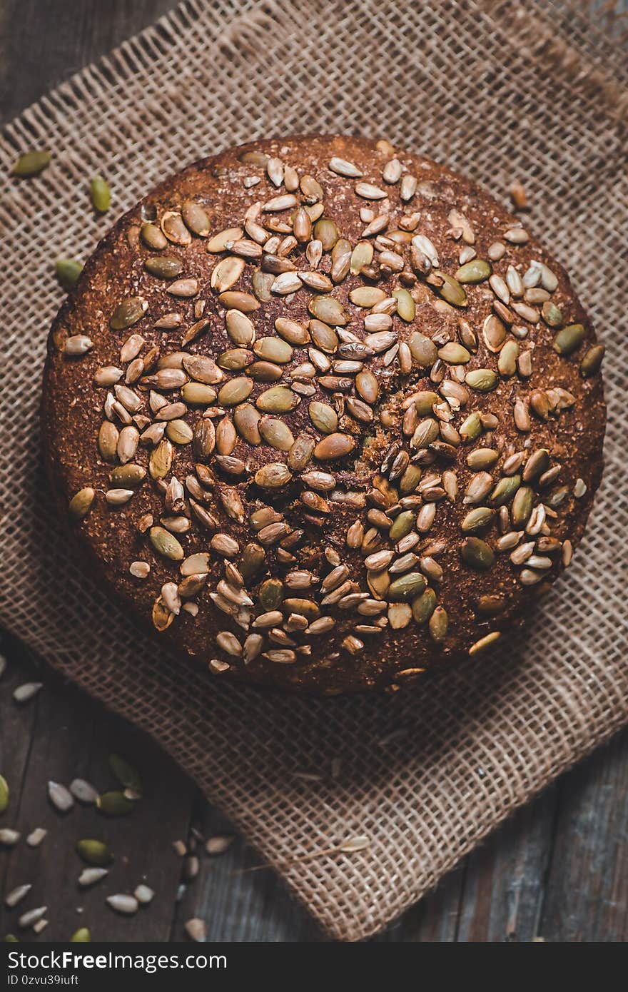 Homemade rye bread with pumpkin seeds on a wooden background