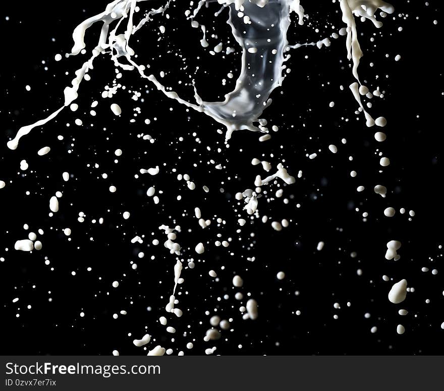 Splashes of white milk isolated on a black background