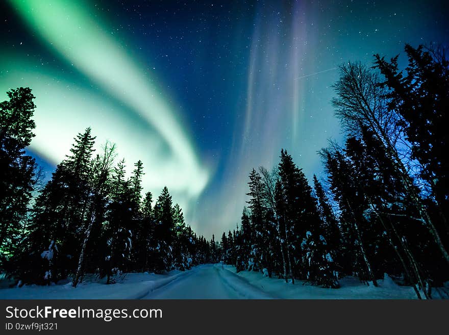 Northern lights Aurora Borealis activity over the road in winter Finland