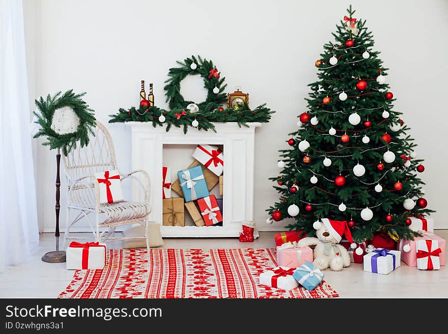 Christmas tree with gifts by the fireplace for the new year decor of the house