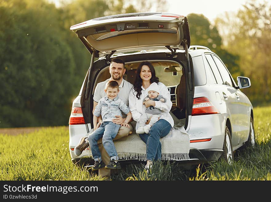 Family in a summer forest by the open trunk