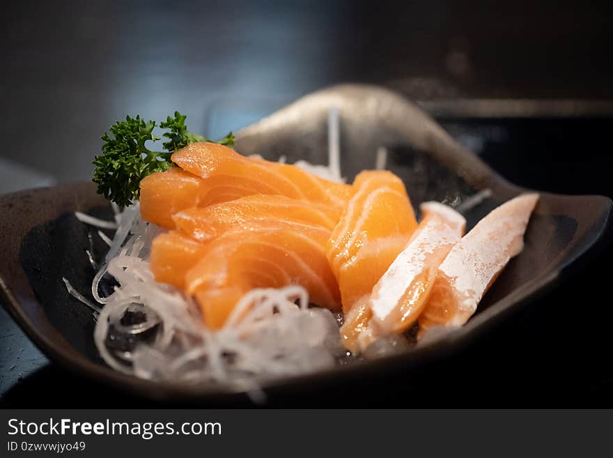 Salmon raw sashimi. Japanese traditional dish on black table. Close up