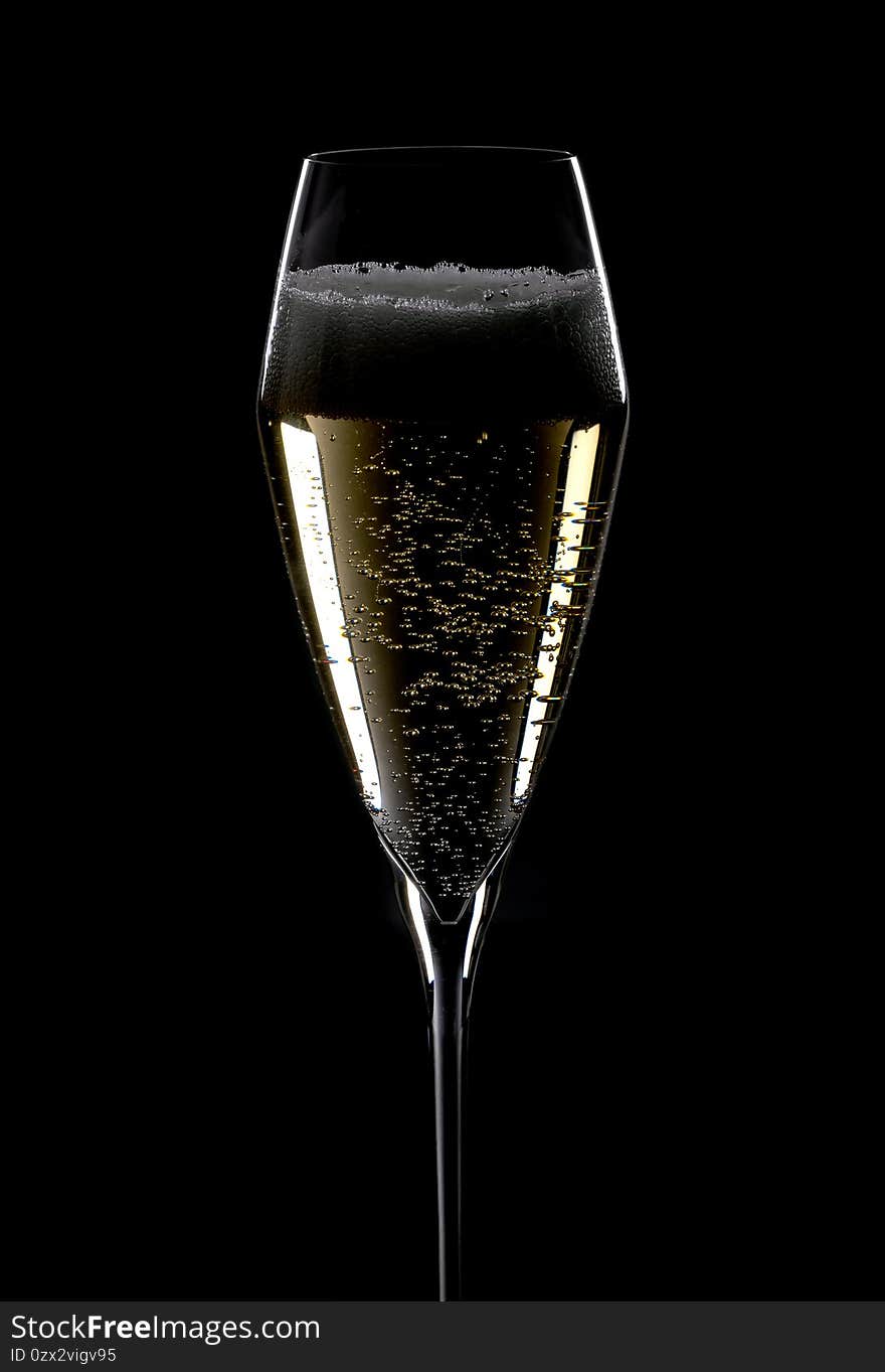 Closeup of an Elegant Crystal Champagne Flute Filled with Sparkling White Wine Isolated on Black Background