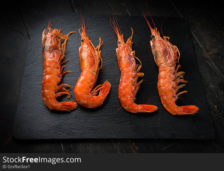 Large langoustines on a black plate. Seafood healthy