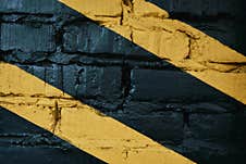 Black Brick Wall With Yellow Stripes At Gym Stock Photography