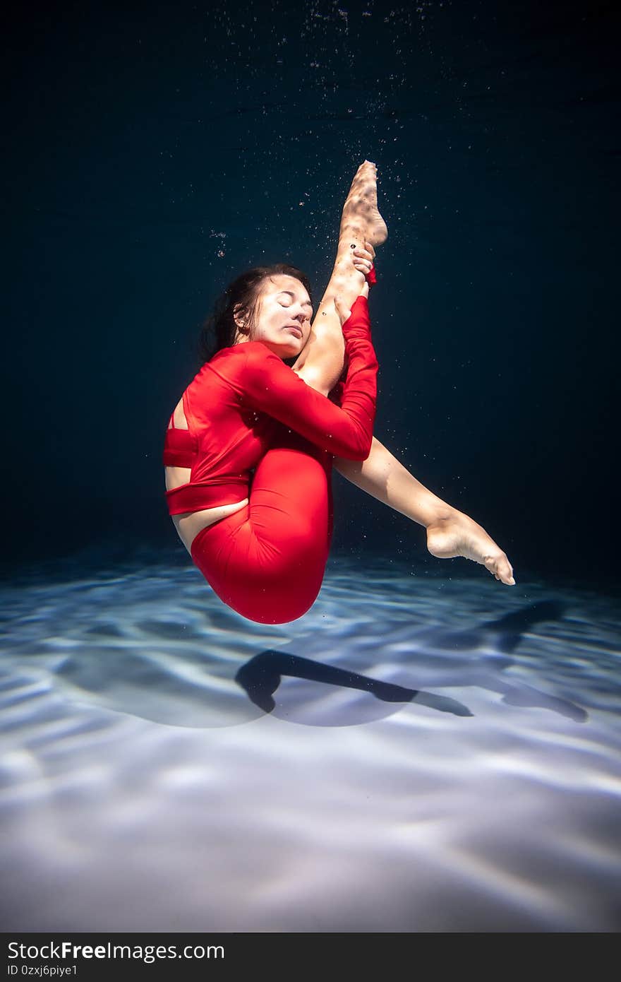 The girl is engaged in yoga under the water in sports clothes. Asanas and Meditation