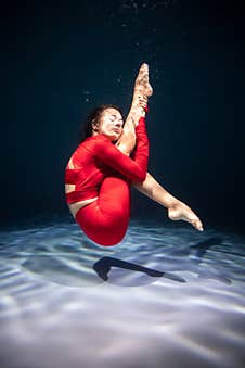 The Girl Is Engaged In Yoga Under The Water In Sports Clothes. Asanas And Meditation Stock Photo