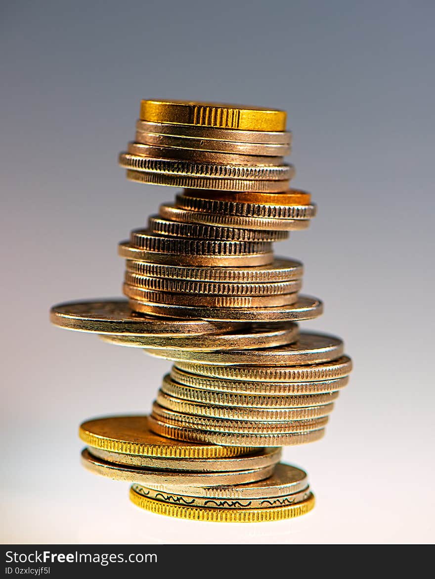 Stack of different coins on a light background