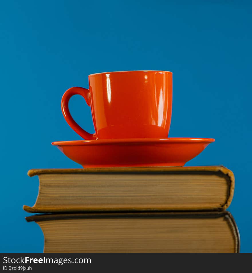 Red cup with coffee stands on a stack of books. Web banner