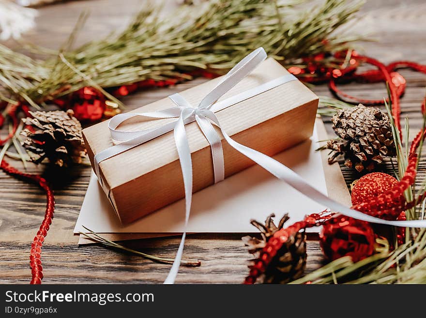 Christmas Gift with fir branch and toys on wooden background. Holiday New Year concept