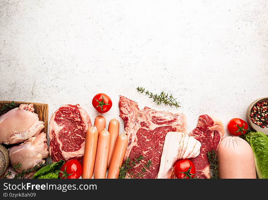 Variety of Fresh Raw meat and sausages on white background. Top view with space for your text. Variety of Fresh Raw meat and sausages on white background. Top view with space for your text