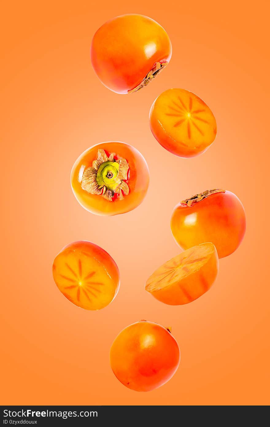 khaki fruits isolated in the air on orange background