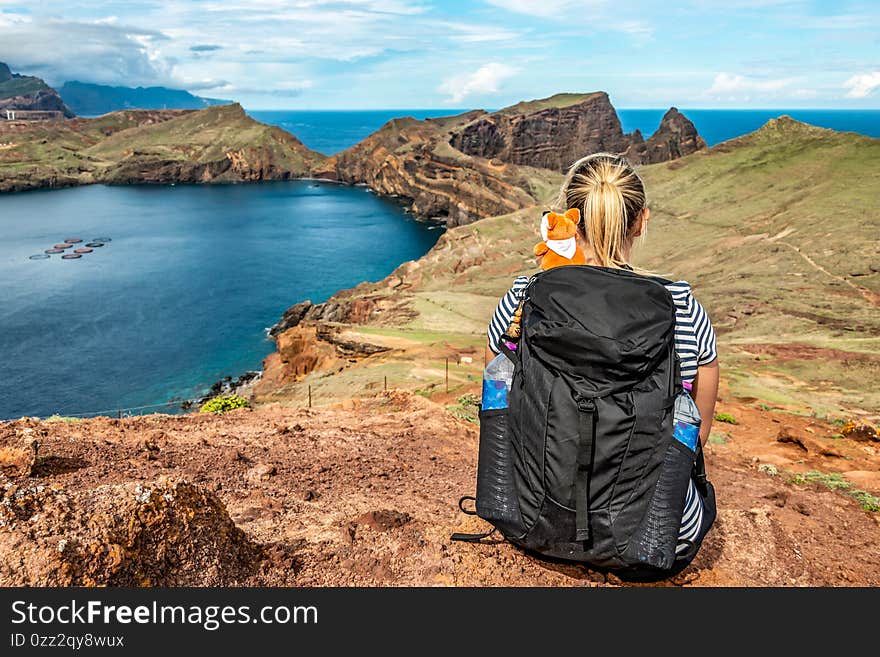 Girl enjoing View rocky cliffs clear water of Atlantic Ocean bay Ponta de Sao Lourenco, the island of Madeira, Portugal