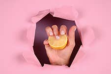 Hand Holds Lemon On A Pink Background Stock Photos