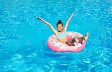 Cute Smiling Little Girl In Swimming Pool With Rubber Ring Stock Photo