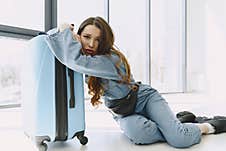 Girl At Home Near Overloaded Suitcase Stock Photography