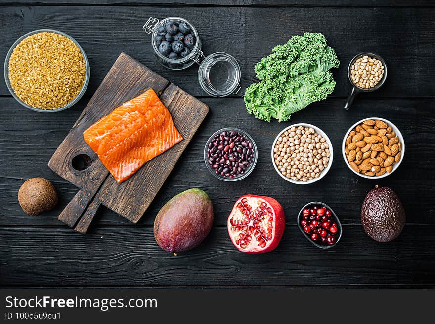 Healthy products with immunity boosters, flat lay, on black wooden background