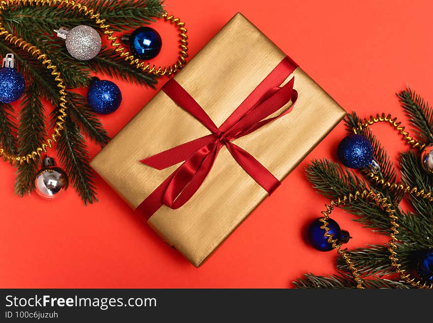 Top view of decorated Christmas tree and gift on red background