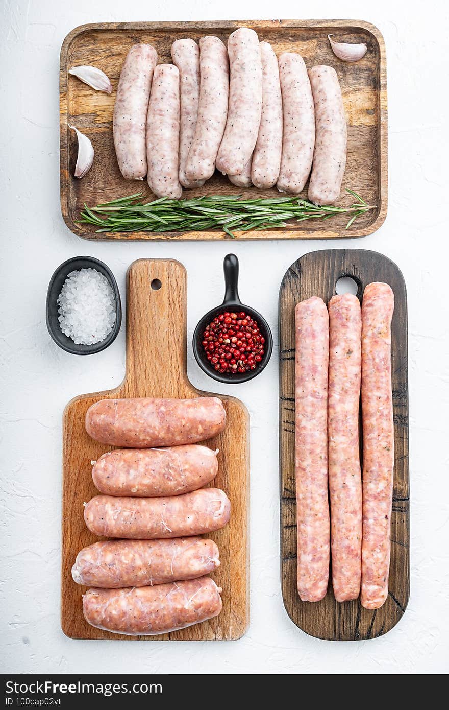 Assorted raw homemade sausages, flat lay, on white background