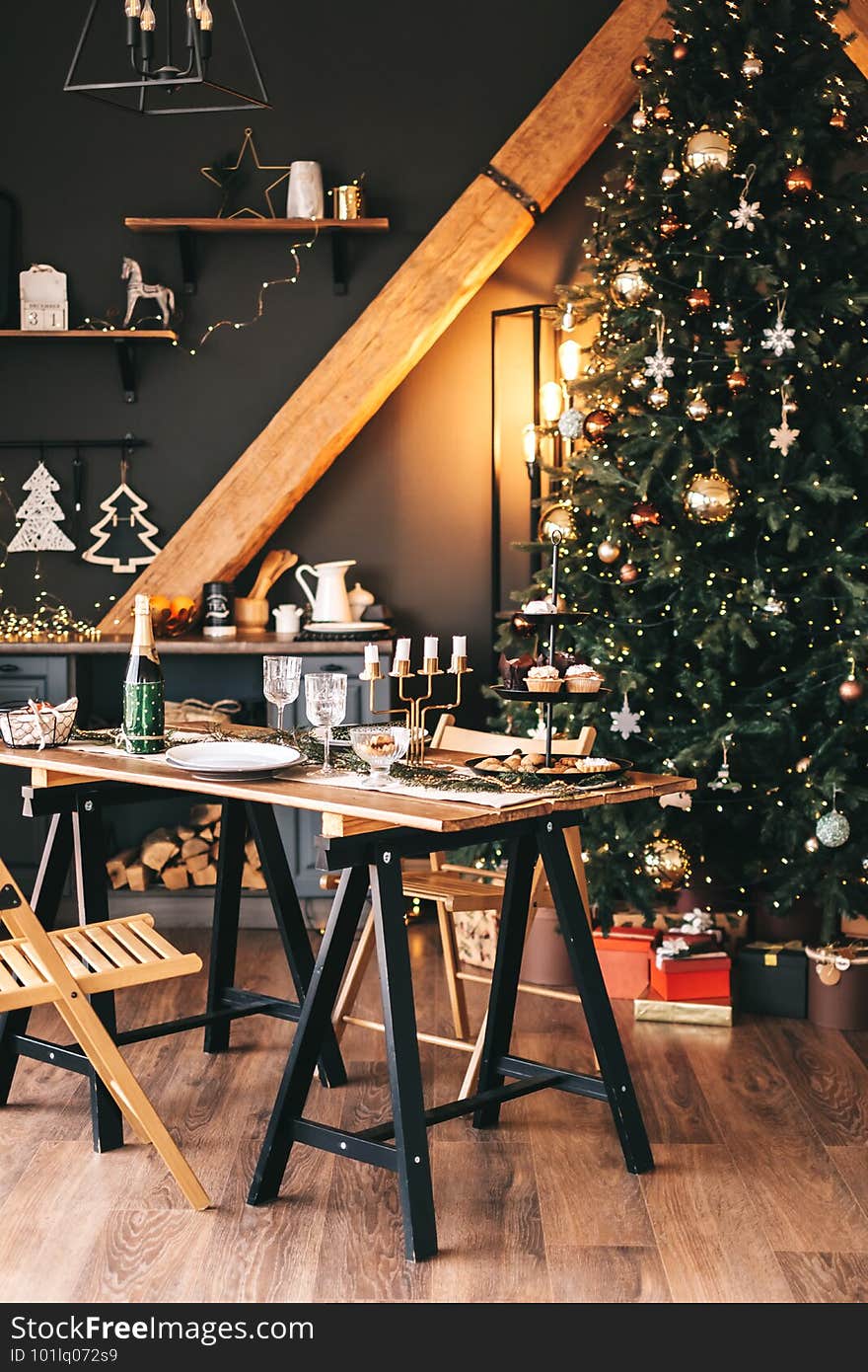 Festive Christmas table in the kitchen with a large Christmas tree and decorations