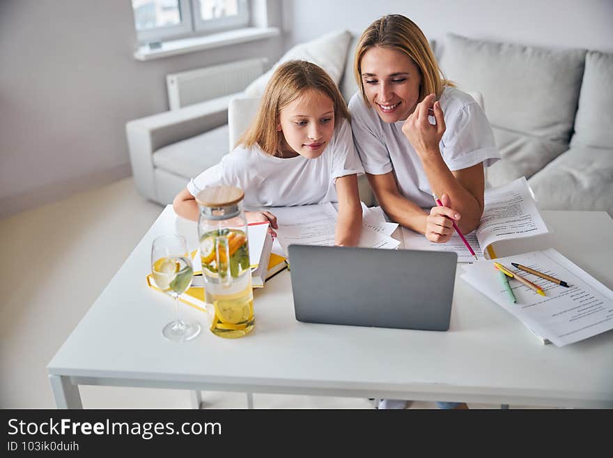 Daughter reaching with her hand to the laptop