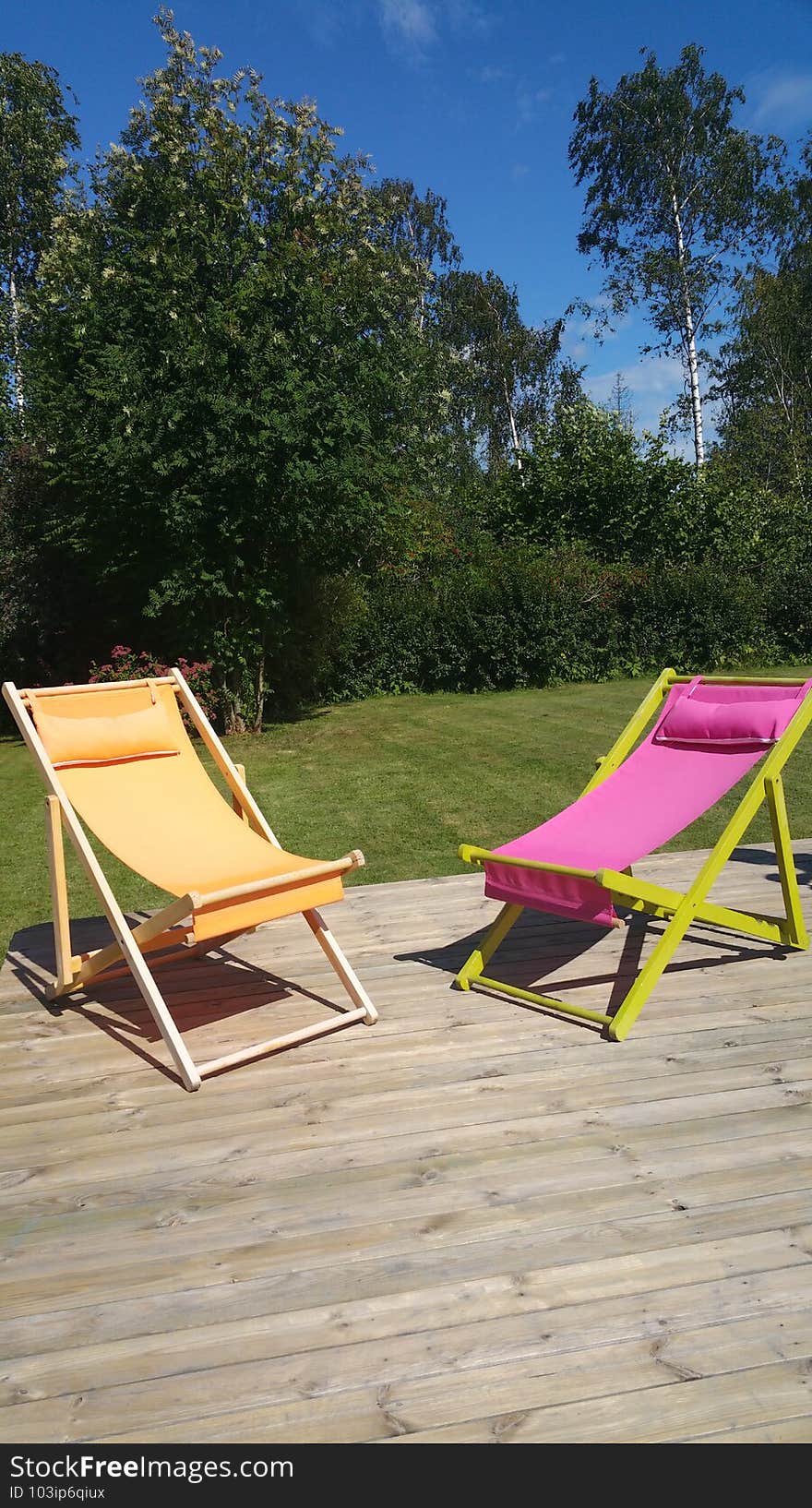 Beach chairs on the wooden terrace with the summer sunshine