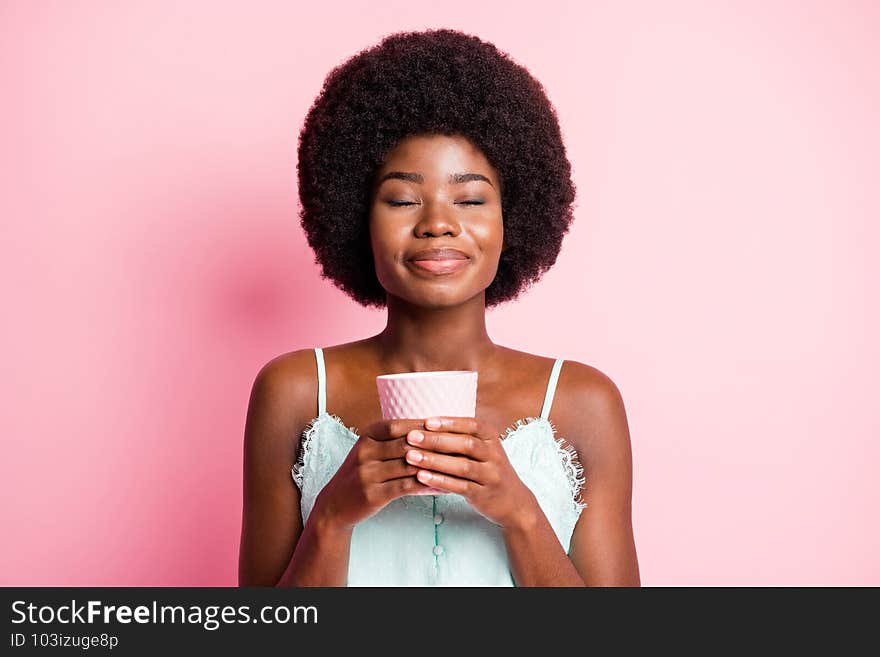 Close up portrait of attractive curly hairdo lady closed eyes hold drink blue tank-top isolated on pink color background