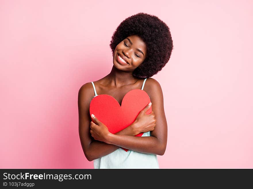 Portrait of curly hairdo lady closed eyes hold heart shape paper blue singlet isolated on pink color background