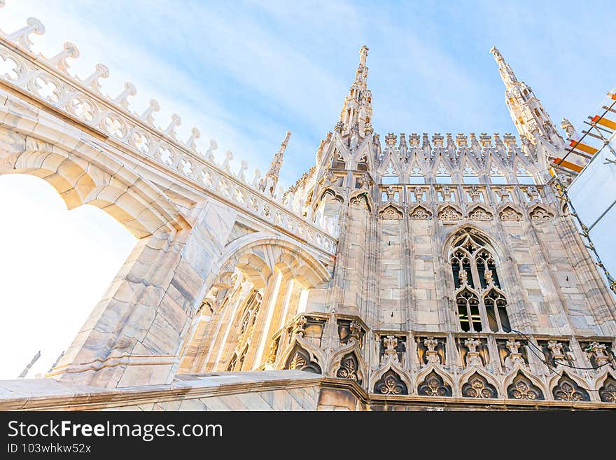 Roof of Milan Cathedral Duomo di Milano with Gothic spires and white marble statues. Top tourist attraction on piazza in Milan