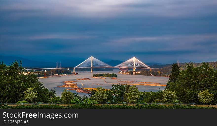 Panoramic views of the Fraser River and Port Mann Bridge against a stormy sky. Trans-Canadian Highway over the Fraser River between Coquitlam and Surrey, British Columbia. Panoramic views of the Fraser River and Port Mann Bridge against a stormy sky. Trans-Canadian Highway over the Fraser River between Coquitlam and Surrey, British Columbia