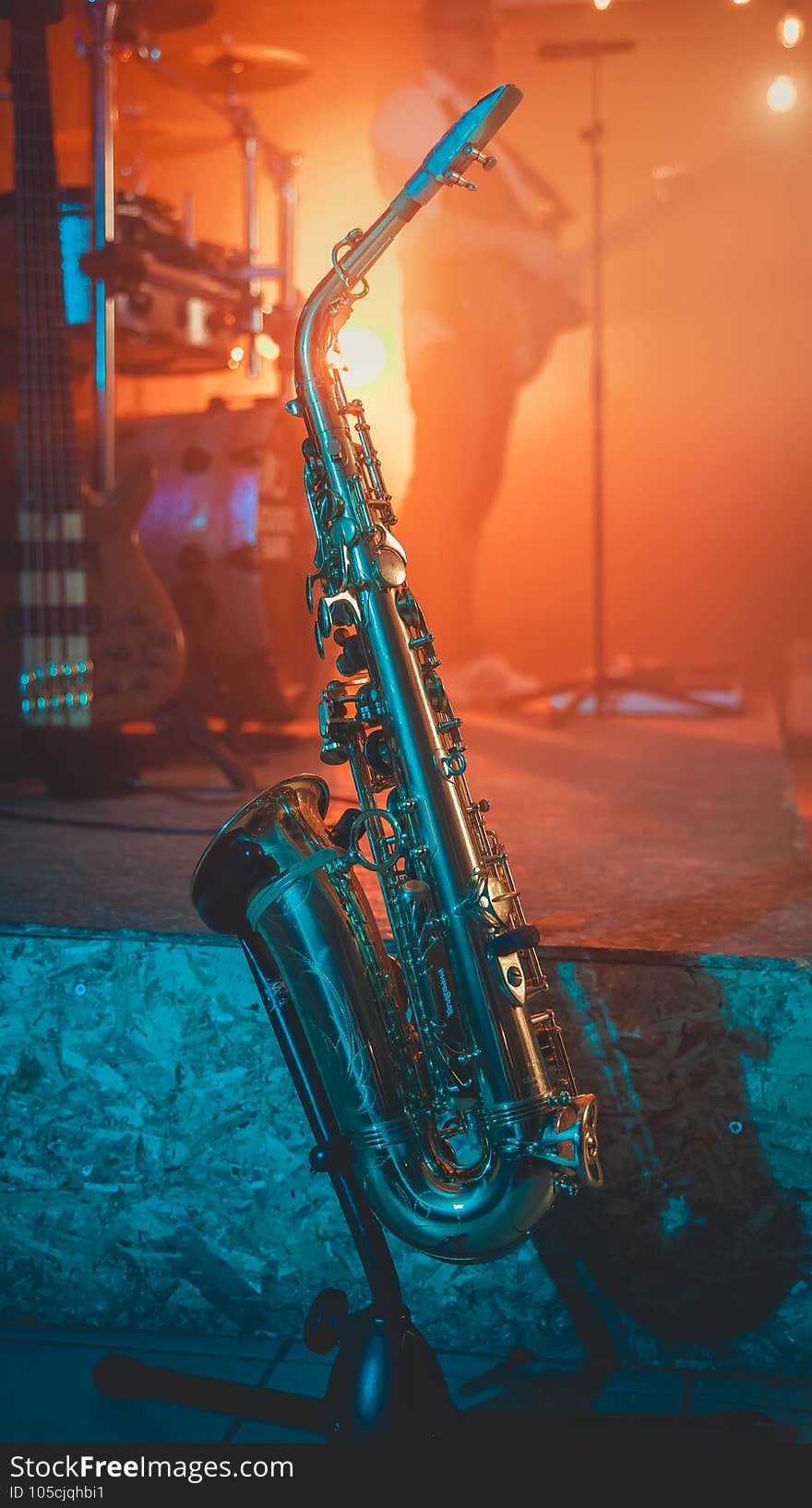 A vertical shot of a saxophone on a stand behind the stage during a concert