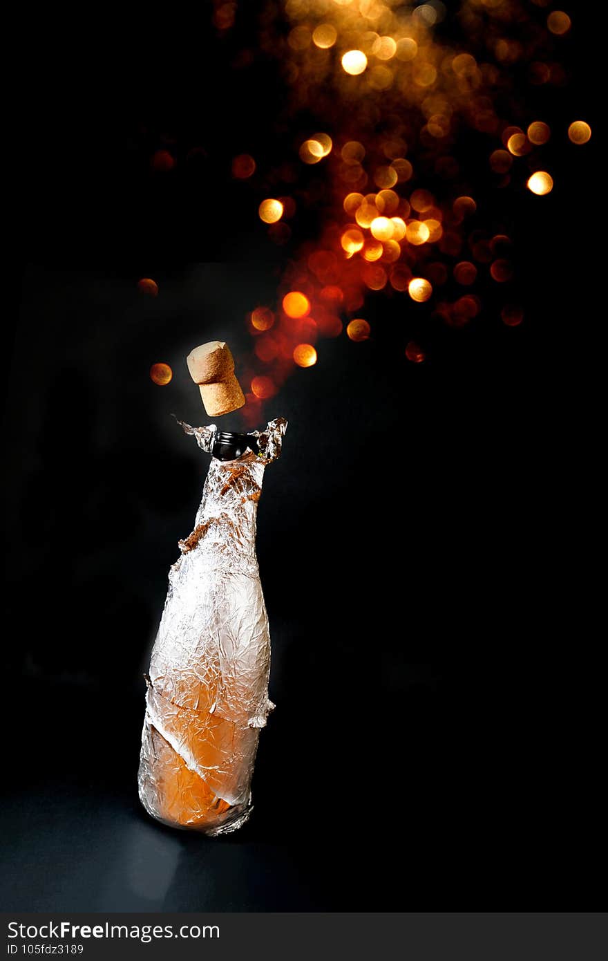 Opened bottle of champagne on a black background. A bottle in a silver box. Background with golden blur and bokeh effect. Close-up, congratulations, postcard.