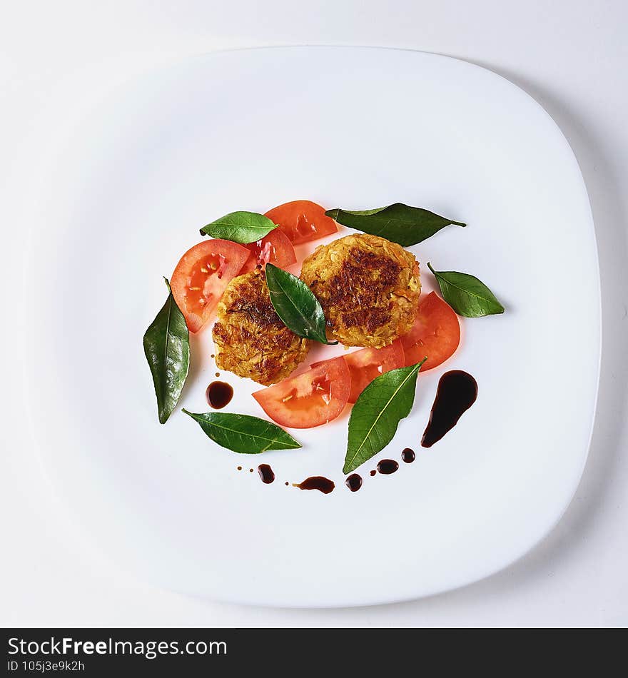 Healthy vegetarian patties made from potatoes, carrots, onions, and green on a background of tomato sauce, selective focus. Healthy vegetarian patties made from potatoes, carrots, onions, and green on a background of tomato sauce, selective focus