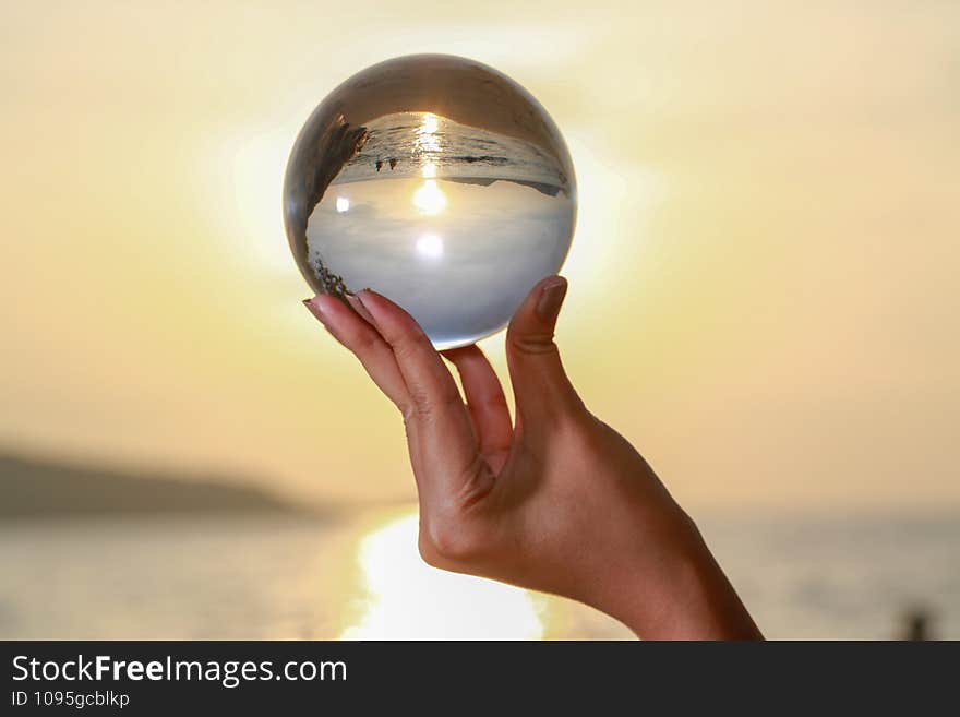 lady catch the crystal ball on her hand beside Patong beach during sunset. .lady catch the crystal ball on her hand beside Patong beach during sunset