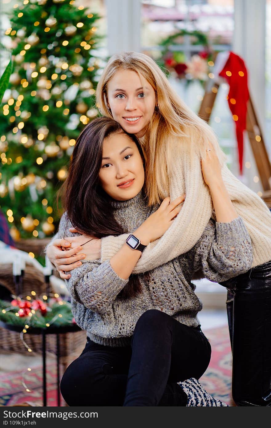 Two cheerful girlfriends on New Year`s vacation in a country house.