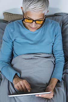 Mature Woman Wearing Blue Light Blocking Eye Glasses, Using Tablet Stock Images