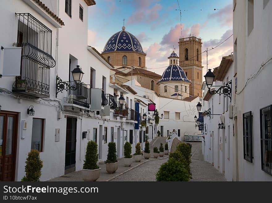 Beautiful shot of a manless street of white houses with the view of a church in Altea Alicante Spain