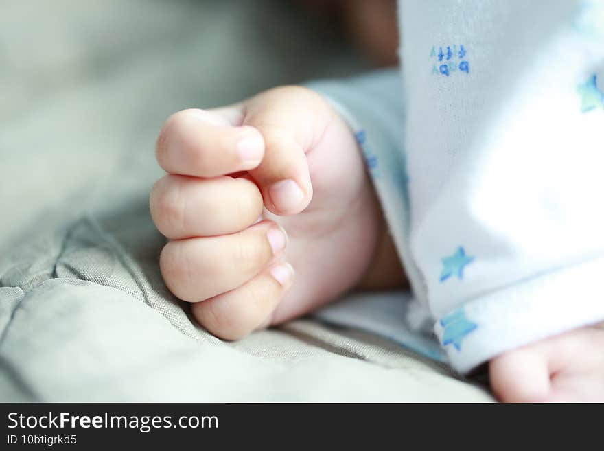 Closeup shot of a cute baby s hand on the bed during a nap