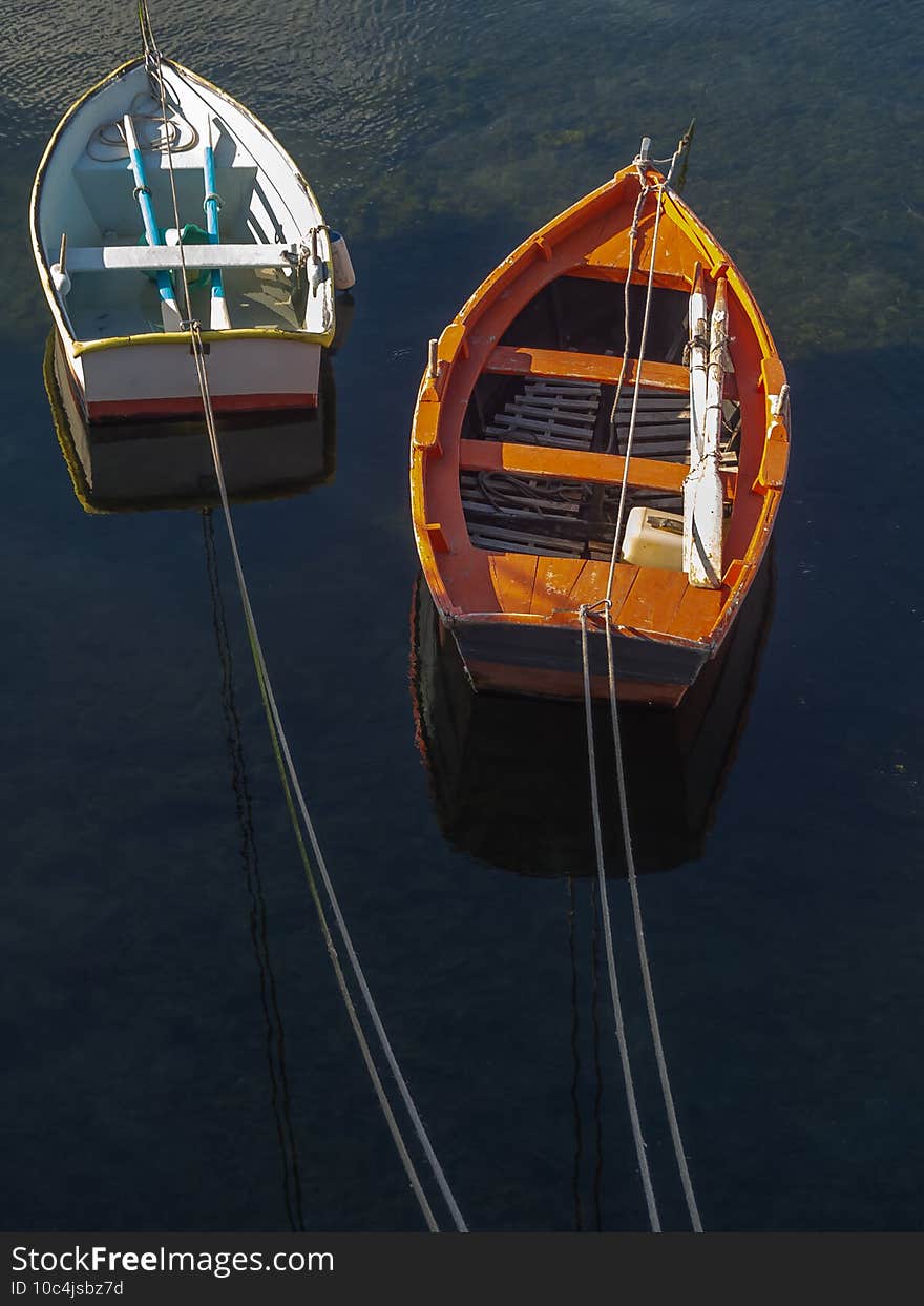 View of two small fishing boats moored in the port. Peace and quiet concept