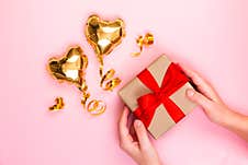 Gold Heart Shaped Balloon And Gift Box With A Red Bow On A Pink Background. Valentine`s Day Concept. Copy Space For Text Royalty Free Stock Photos