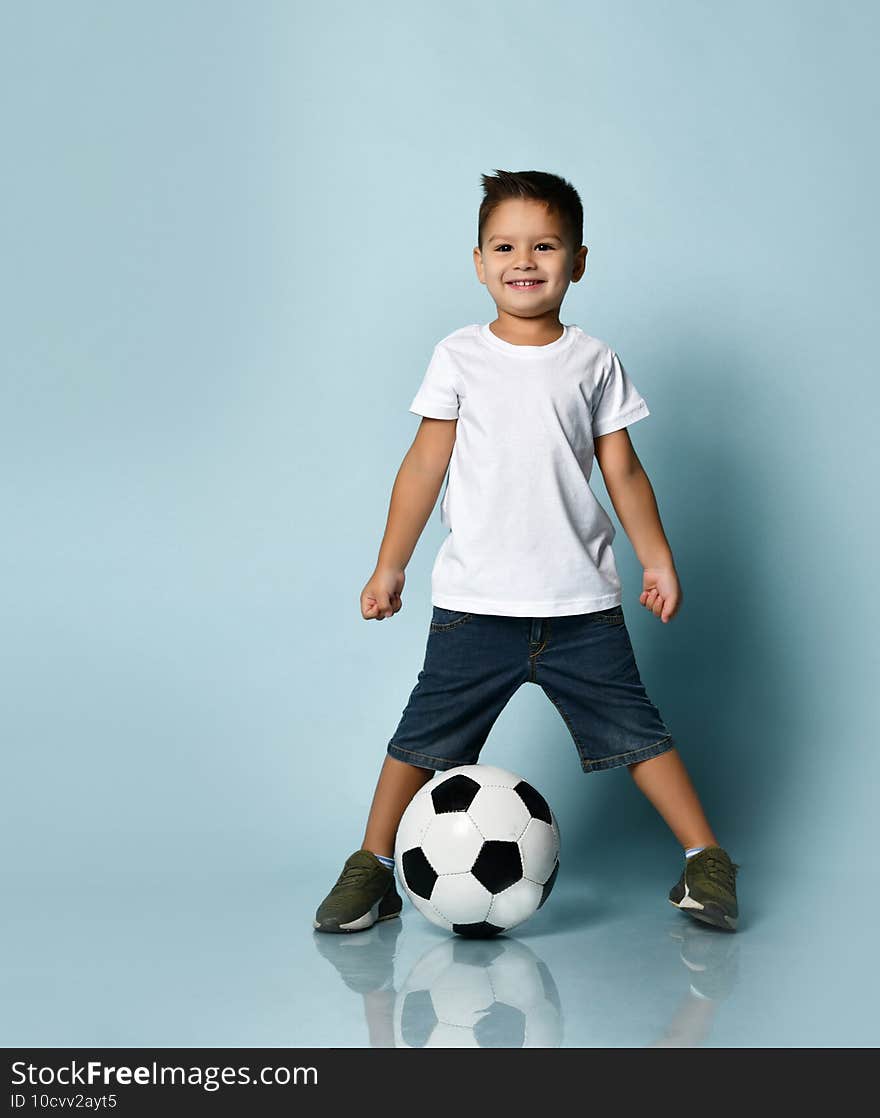 Boy playing soccer, happy child, young male teenager goalkeeper enjoying sports game, holding ball