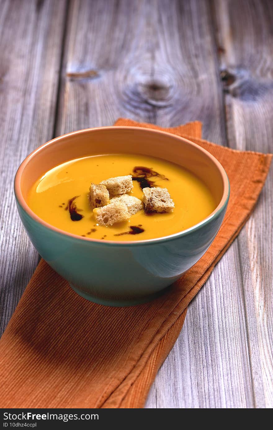 Vertical selective focus closeup of the soup in a bowl on a wooden table