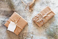 Scandinavian Style Winter Background - Brown Paper Wrapped CHristmas Gifts With Pine Cones And Jute Rope On White Winter Royalty Free Stock Images