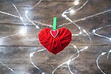 A Red Heart Is Suspended From A Rope Against The Background Of A Burning Garland. Royalty Free Stock Images