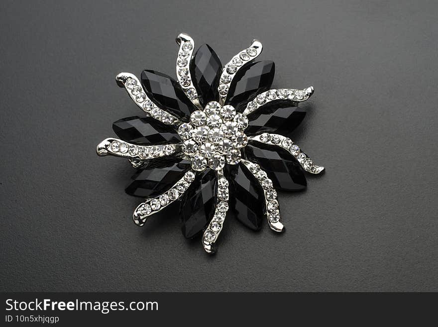 round brooch flower with gems stones isolated on black.