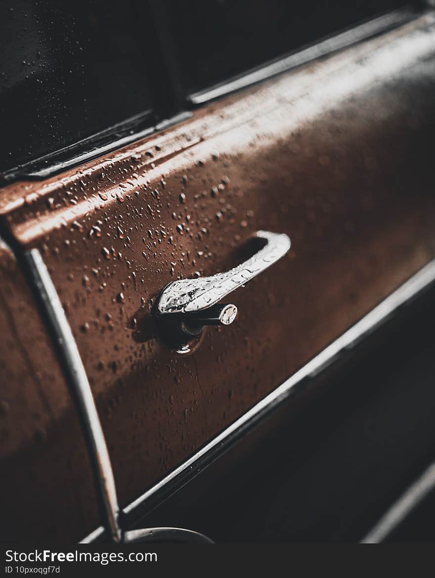 Beautiful shot of a door of a car with raindrops