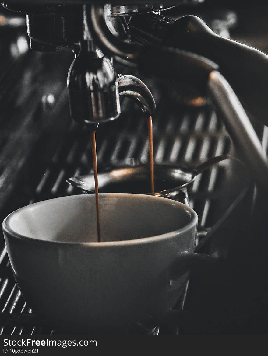 Amazing shot of a working coffee machine and filling a cup with ciff