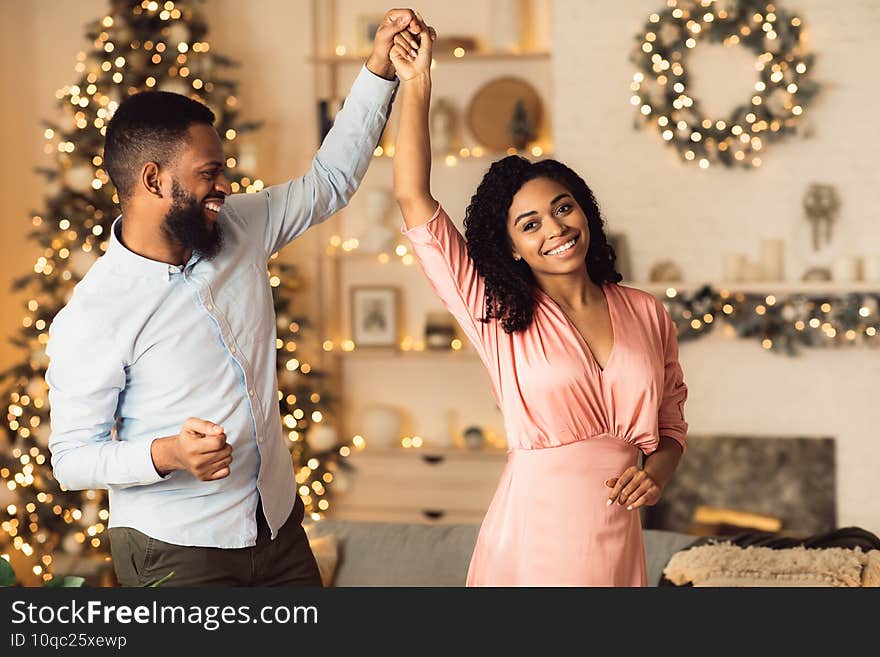 Love And Affection. Portrait of smiling millennial african american men and women dancing. Happy black couple enjoying spending time together at a party at home, celebrating event. Love And Affection. Portrait of smiling millennial african american men and women dancing. Happy black couple enjoying spending time together at a party at home, celebrating event