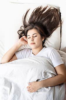 Young Beautiful Brunette Woman Sleeping In Bed Royalty Free Stock Photos