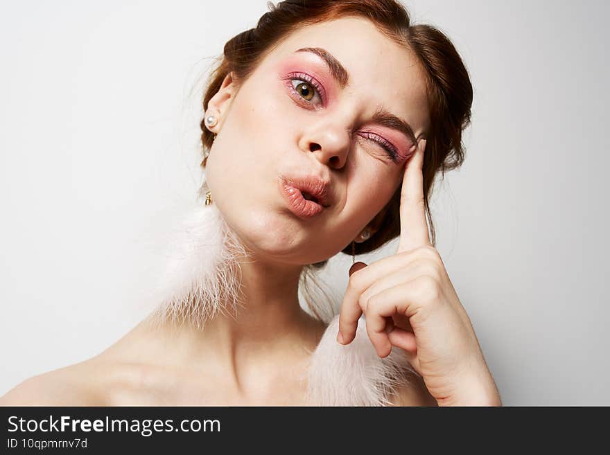 cheerful woman naked shoulders fluffy earrings bright makeup closeup